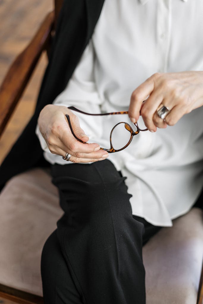Professional woman holding eyeglasses during a counseling session indoors.